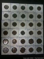 Photo showing 20 coins mounted in individual holders labeled with year and denomination, mostly 1 cent coins from 1948 to 1976.