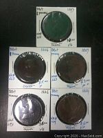 Front view of all five copper British pennies dated 1797, 1806, 1807, 1826, and 1854, individually sleeved in white holders with plastic window. Coin grades range from fair to very good.