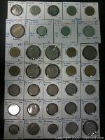 Full view of all 34 coins arranged in rows on white labeled holders indicating country, year, denomination, and condition notes.