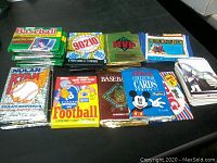 Photo showing 12 card packs and loose cards including Topps 1990 baseball stickers, 90210, MVP, Return of the Jedi, Nolan Ryan baseball, football, and Disney cards