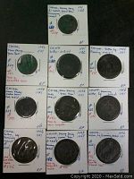 Photo of 10 ancient Chinese coins each mounted individually with annotations. Shows coins' fronts, inscriptions, and square holes.