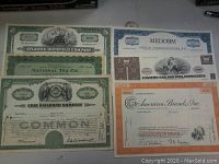 Six stock certificates displayed showing various company names and colorful borders.