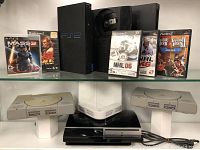 Shelved view showing multiple PlayStation consoles and game cases