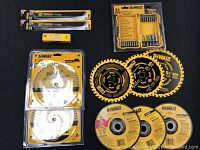 Photo of 2 jig saw blades, a yellow screwdriver bit box, 3 diamond saw blades, and 3 circular cutting/grinding discs on black background.