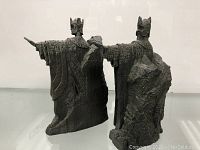 Rear and side views of the two Lord of the Rings bookends showing textured armor and rocky bases.