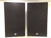 Front view of both speakers with black cloth grilles attached, showing Wharfedale logo on lower baffle.