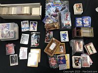 Overview of the card lot showing assorted trading cards, packs, and boxes including hockey cards, Pokémon cards, Magic: The Gathering packs, and a hockey player figure