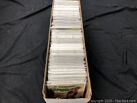 Long cardboard box filled with dozens of comic books packed upright