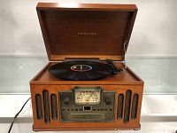 Full view of Crosley model CR74 record player with wooden cabinet and open lid playing a vinyl record.