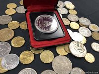 Top view of Canadian silver dollar coin in display case surrounded by various other coins