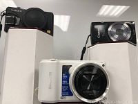 Front view of Panasonic Lumix, Canon PowerShot, and Samsung cameras showing front lens and body details