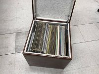 Open vinyl record storage case filled with a large number of used vinyl records