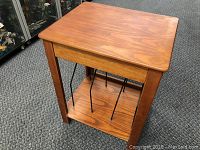 Wooden record stand showing front and side views with metal supports for record storage.