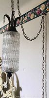 Photo showing one swag hanging lamp with crystal style glass cylinder and decorative metal fixture with chains to hang it.