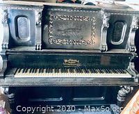 Front view of Mathushek Cottage upright piano showing ornate carvings and keys