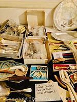 Overview of multiple boxes and trays of flatware and serving utensils