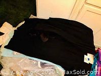 Black women's dress or suit laid out flat with tags attached