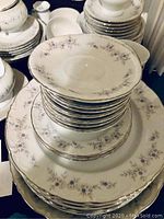 Stack of plates showing floral pattern and silver trim