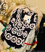 Black women's top or dress with large white floral or circular sequin decoration, part of the 41-item clothing lot.