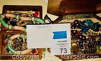 Two wooden boxes filled with assorted costume jewelry including bangles, bead necklaces, faux pearls and chains