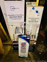 Photo showing boxed Mainstays adjustable 2-tier rolling garment rack, adjustable rolling corner garment rack, and shoe rack.