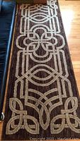 Brown and beige runner rug with geometric floral pattern and linear lines