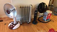 Photo showing all five items together: Kuhaus oscillating dish heater, Delonghi oil filled heater, Ionic Breeze air cleaner, Vornado floor fan, LightAir air purifier box.