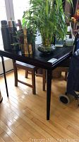 Folding card table with items placed on top and two wooden ladderback chairs underneath.