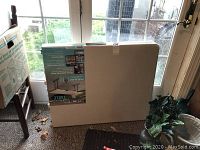 Folded Lifetime brand folding table in vinyl, leaning against a door.