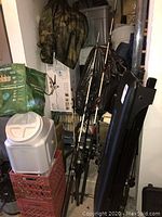 Four fishing rods leaning in storage closet with reels attached