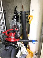 Full view of the items showing red Toro blower vac, black Euro-Pro floor steamer, and three snow shovels.