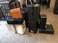 Overview photo showing all items including speakers, receiver, camera in case, and Onkyo components stacked together