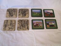 Eight coasters: four black and white illustrated tile coasters and four European country scene photo coasters with green borders