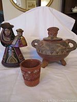 Overview of three South of the Border souvenir items including figurine, pot, and cup on white background