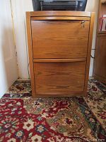 Front view of the two drawer wood file cabinet showing the grain pattern, drawer handles, and key lock.