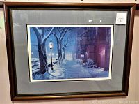 Full view of the framed print showing the winter street scene under glass with some reflections visible.