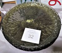 Five vintage green Arcoroc glass plates stacked, showing textured floral design and size label
