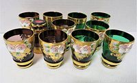 Eleven glasses in two colors with hand painted floral and gold trim arranged in two rows