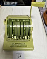Front view of the Paymaster check writer showing number dials for dollars and cents and front warning text.