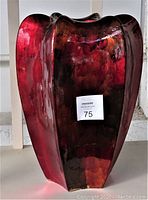 Front view of large metallic red vase with shiny finish and sculpted vertical ridges