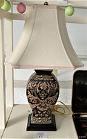 Front view of the 25 inch ceramic oriental lamp with shade, showing detailed patterns on the base and beige shade.