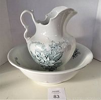 Vintage white ceramic basin and pitcher with green floral design shown together