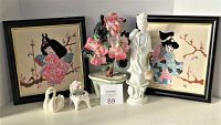 Lot showing two framed needlepoint art pieces, porcelain lady figurine, miniature swan and chair ceramics, and pink floral arrangement.