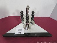 Triangle black and white marble cheese board with knives displayed upright in metal stand