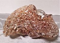 Side angle view of the red and brown speckled vintage Murano art glass bowl showing clear blown handles and unique curved shape.