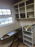 Photo showing antique wooden ironing board with two wooden washboards inside it near a window