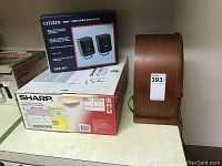 Photo showing wooden vintage Prosonic radio, boxed Citizen SSX-301 speakers, and boxed Sharp video cassette recorder