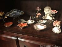 Full view of shelf with all floral ornaments, ring holders, small jewelry dishes, and the opalescent glass bowl