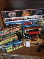 Photo showing all boxed train sets and accessories arranged including Canadian Action Master, Western Train Set, Tyco and Atlas boxed models.
