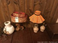 Photo showing all three vintage lamps placed on a wooden surface against a wooden wall.